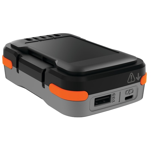 A close-up view of a BLACK+DECKER electronic device with orange accents, showing USB ports and indicator symbols. The item has a durable, portable design.