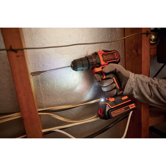 BLACKDECKER BDCDD186 cordless drill being used, visible lithium 18V battery, close-up indoor setting.
