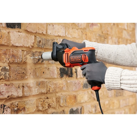 BLACKDECKER BEH850 corded hammer drill used on brick wall, product photography, side angle