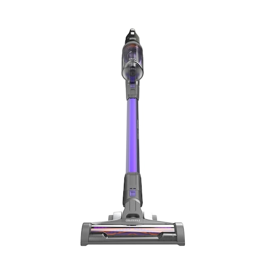 A cordless stick vacuum cleaner with a purple and grey design, shown upright on a white background. The vacuum has a transparent dust container and a brush head at the bottom.