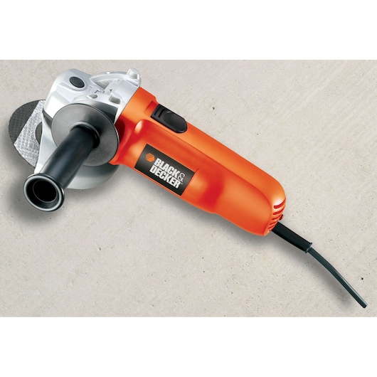 An orange BLACK+DECKER angle grinder with a black handle and power cord, placed on a light-colored surface.