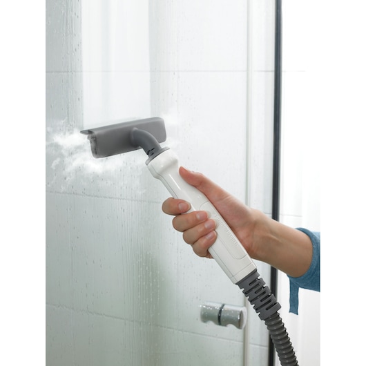 BLACK+DECKER FSMH13101SM steam cleaner attachment in use on glass shower door, close-up angle.