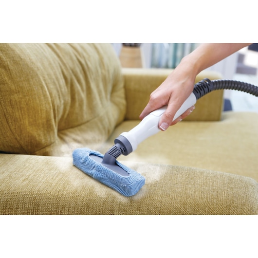 BLACK+DECKER FSMH13101SM steam cleaner cleaning yellow couch with blue microfiber pad, close-up angle.