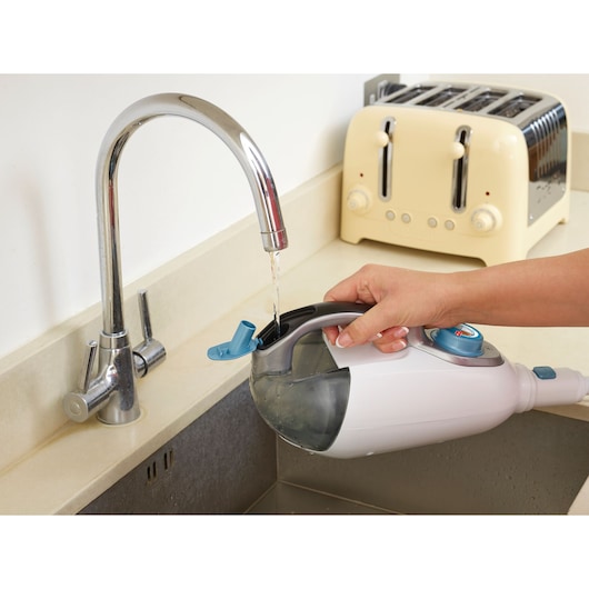 BLACKDECKER FSMH13101SM steam cleaner water tank being filled under kitchen tap, close-up.