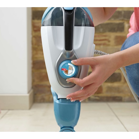 Photo of BLACKDECKER FSMH13101SM steam mop with close-up of hand adjusting blue and white control dial.