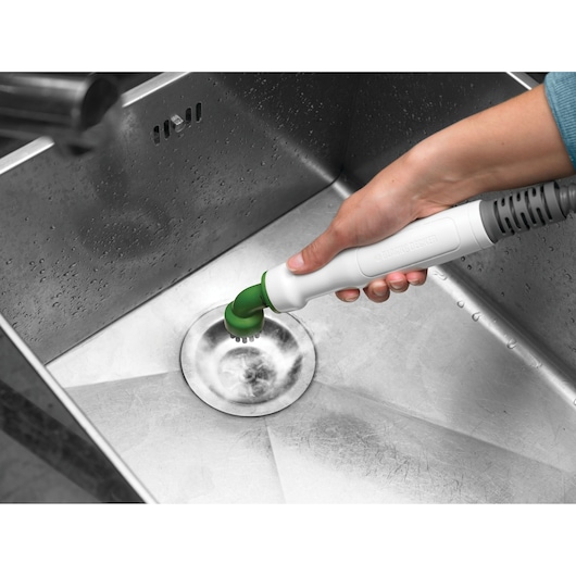 Photo of BLACKDECKER FSMH1351SM steam cleaner with green brush attachment cleaning a stainless steel sink.