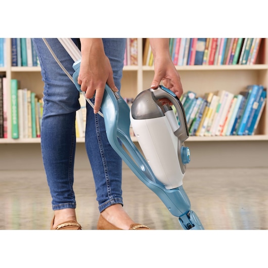 BLACKDECKER FSMH1351SM steam mop with detachable handheld unit, person using on floor near bookshelf.